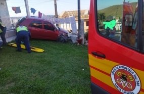 Carro invade pátio de residência após colidir em poste de energia elétrica