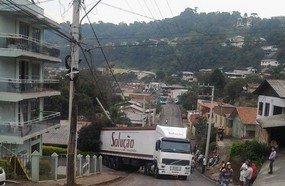 Carreta não consegue subir rua e por pouco não atinge casa